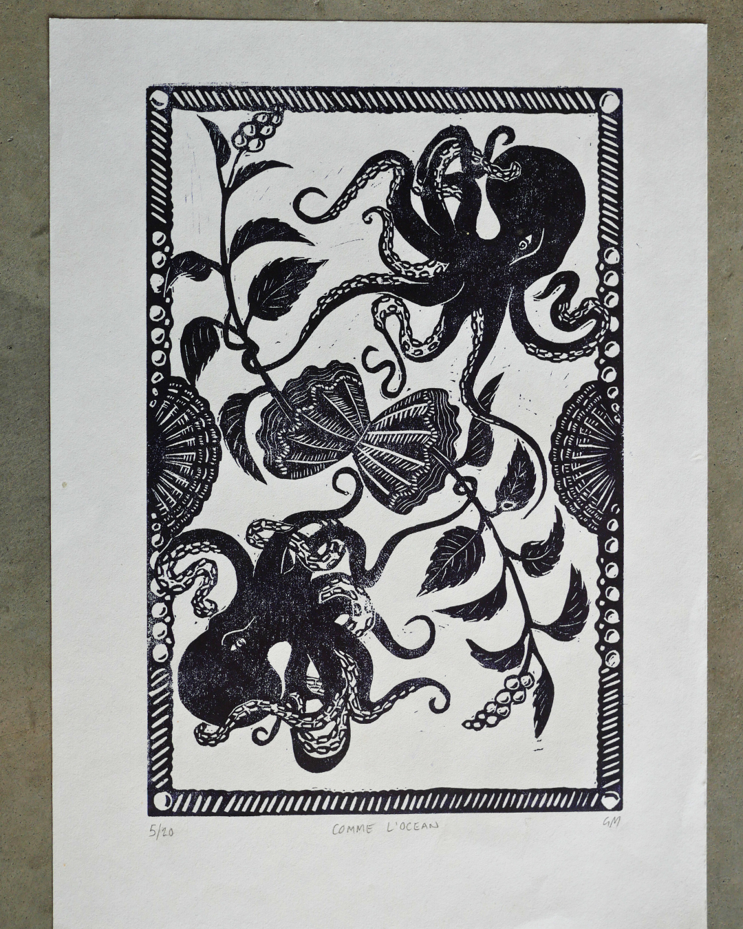Black and white linocut print of octopuses and sea life on a white background